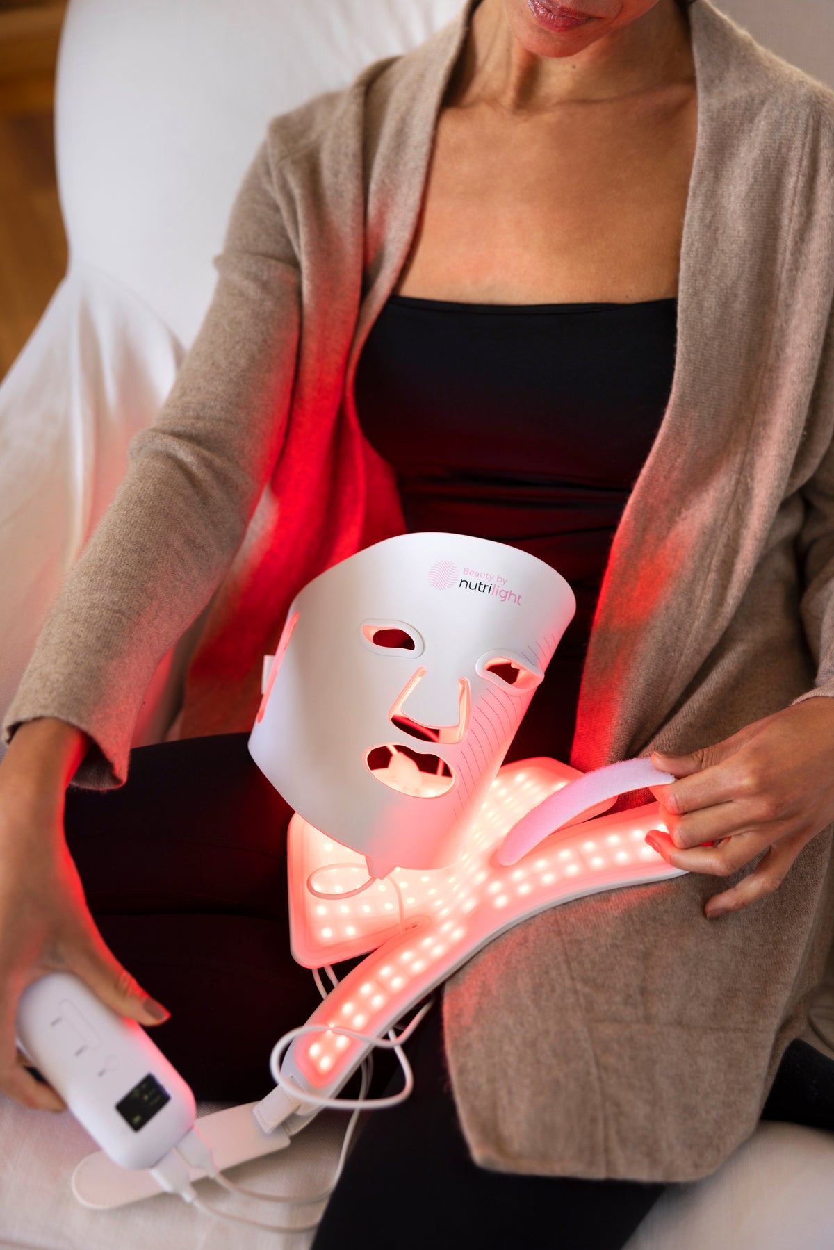 Kvinde med The Lynx LED-maske tændt i rødt