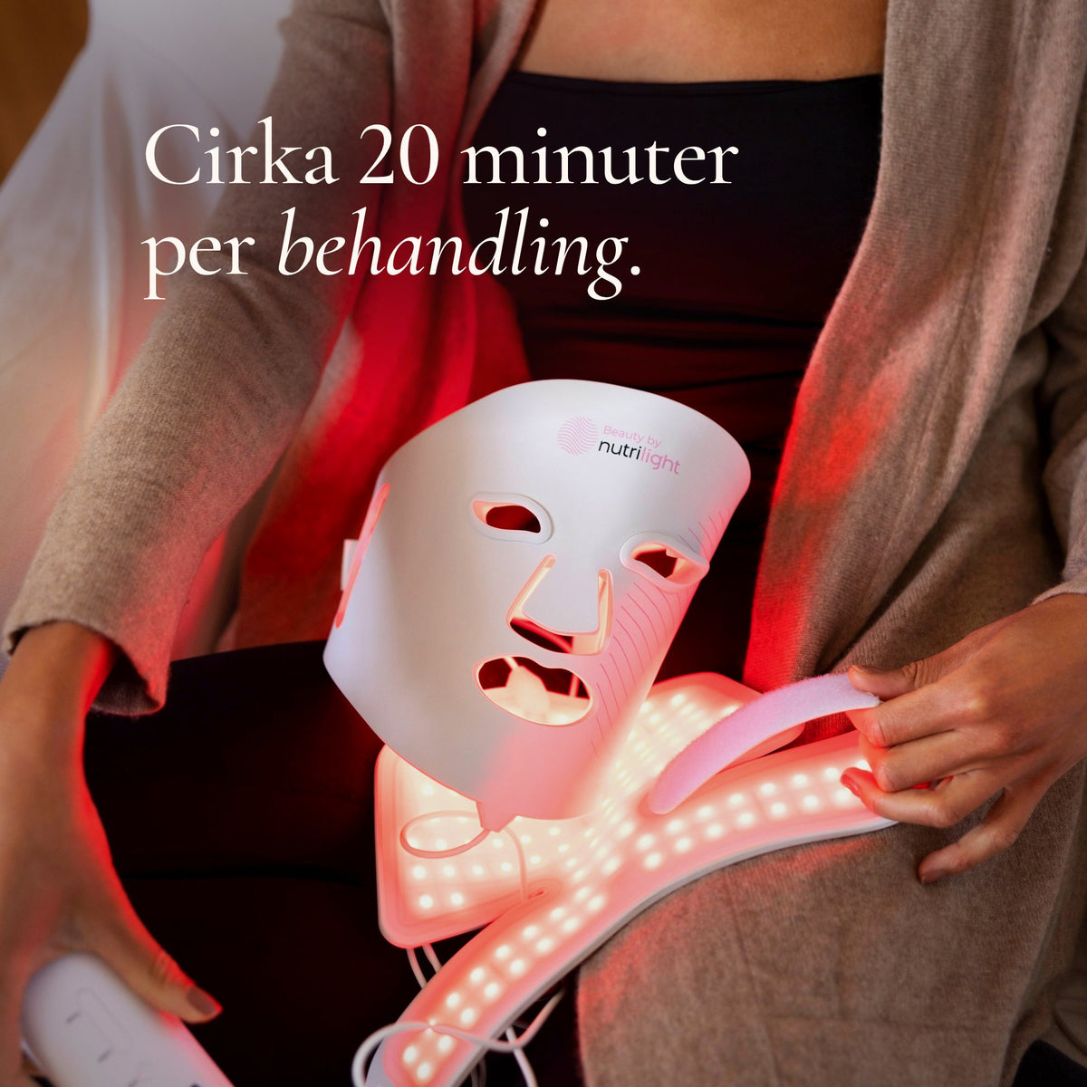 The Lynx LED-mask och halsdel lyser rött i händerna på en kvinna. Cirka 20 minuter per behandling.