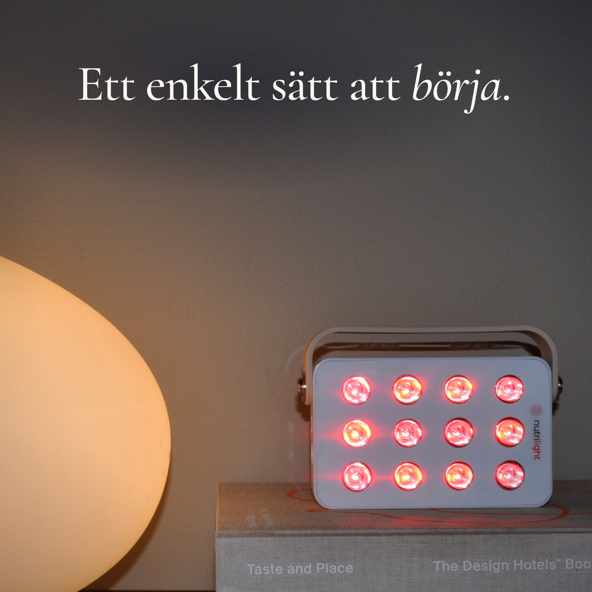 Robin Gen 2 lyser rött på en bokhög ved siden af en bordlampe. En enkel måde at komme i gang med rødt lys på.