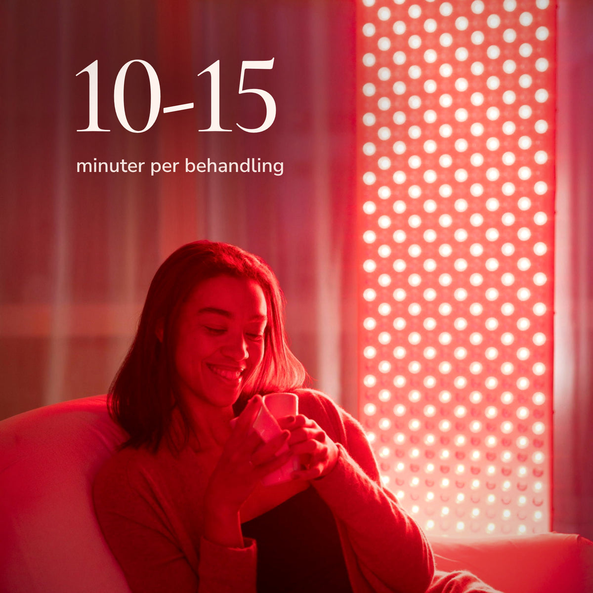 Woman sits relaxed with a cup in front of the lit The Red Kangaroo. A treatment takes 10-15 minutes.